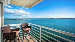 A balcony with wicker chairs and a view of a large body of water. - Bahia Vista 17-881 by Distinctive Beach Rentals (St. Petersburg)