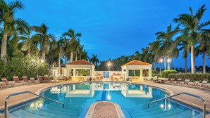 A swimming pool with lounge chairs and palm trees. - Bahia Vista 17-881 by Distinctive Beach Rentals (St. Petersburg)