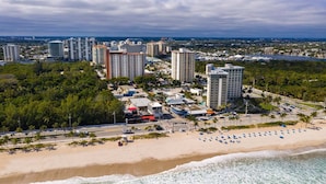 Paisatge urbà costaner amb edificis alts, una platja i un port esportiu.