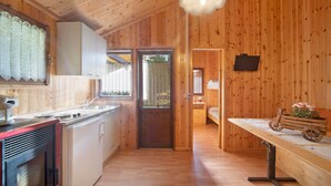 Un intérieur en bois comprenant une cuisine, un coin repas et une chambre.