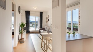 Een moderne woonkamer met een bank, een eettafel en een potplant.