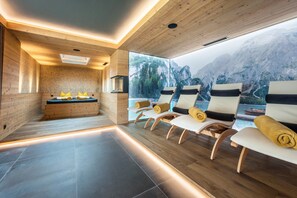 A modern spa room with wooden walls, a large window overlooking mountains, and several lounge chairs with towels. - Apartment "Waidacherhof Berg" with Mountain View, Balcony & Wi-Fi (Prags)