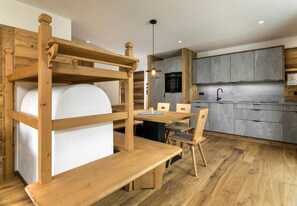 A modern kitchen with grey cabinets, a wooden dining table, and a bench. - Apartment "Waidacherhof Wiese" with Mountain View, Balcony & Wi-Fi (Prags)