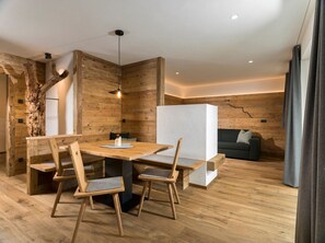 Un intérieur moderne avec une table à manger en bois, des chaises, un séparateur blanc et un canapé.