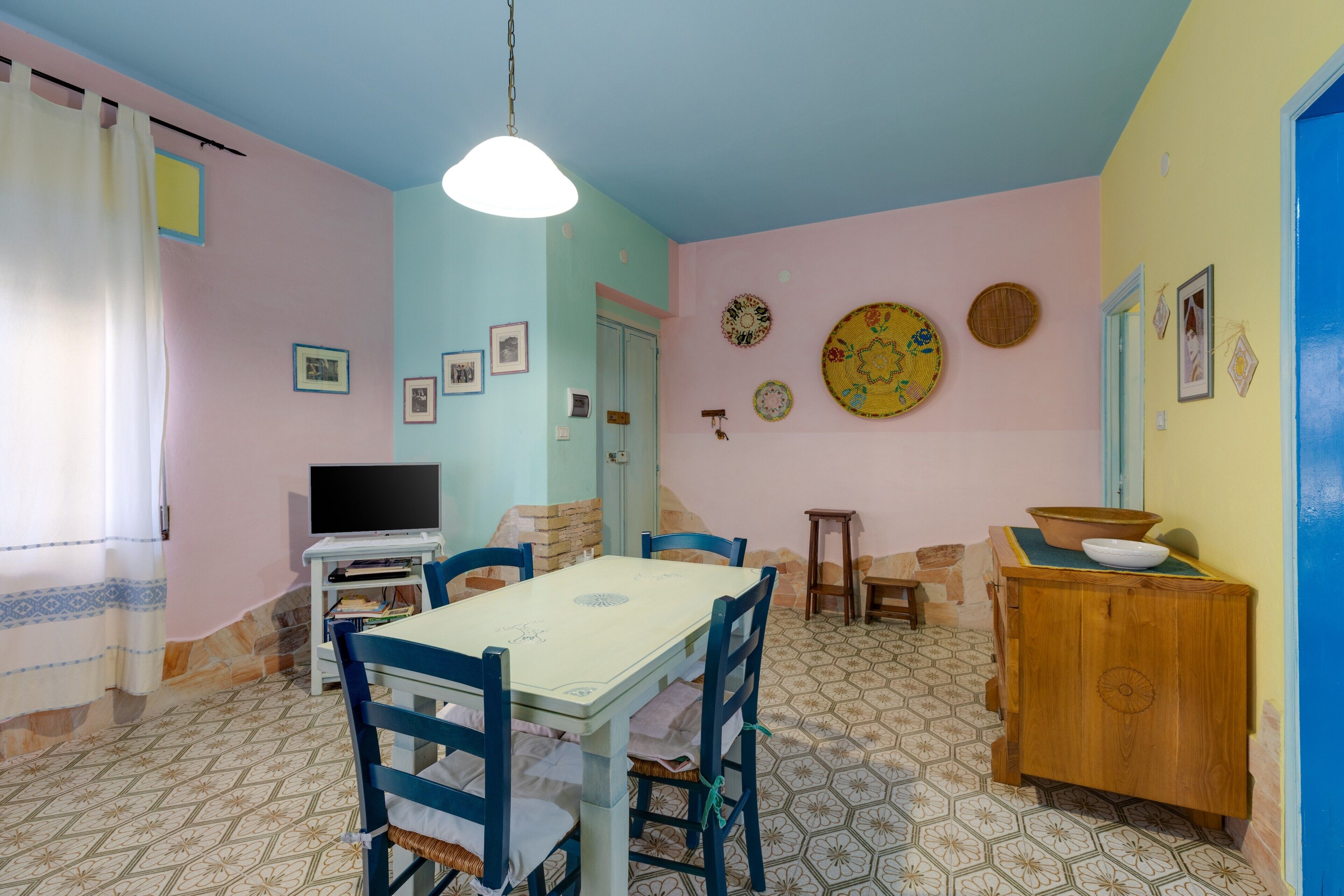 Un espace repas comprenant une table, des chaises, un téléviseur et un meuble.