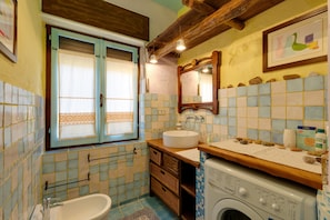 A bathroom with a bathtub, sink, and washing machine.
