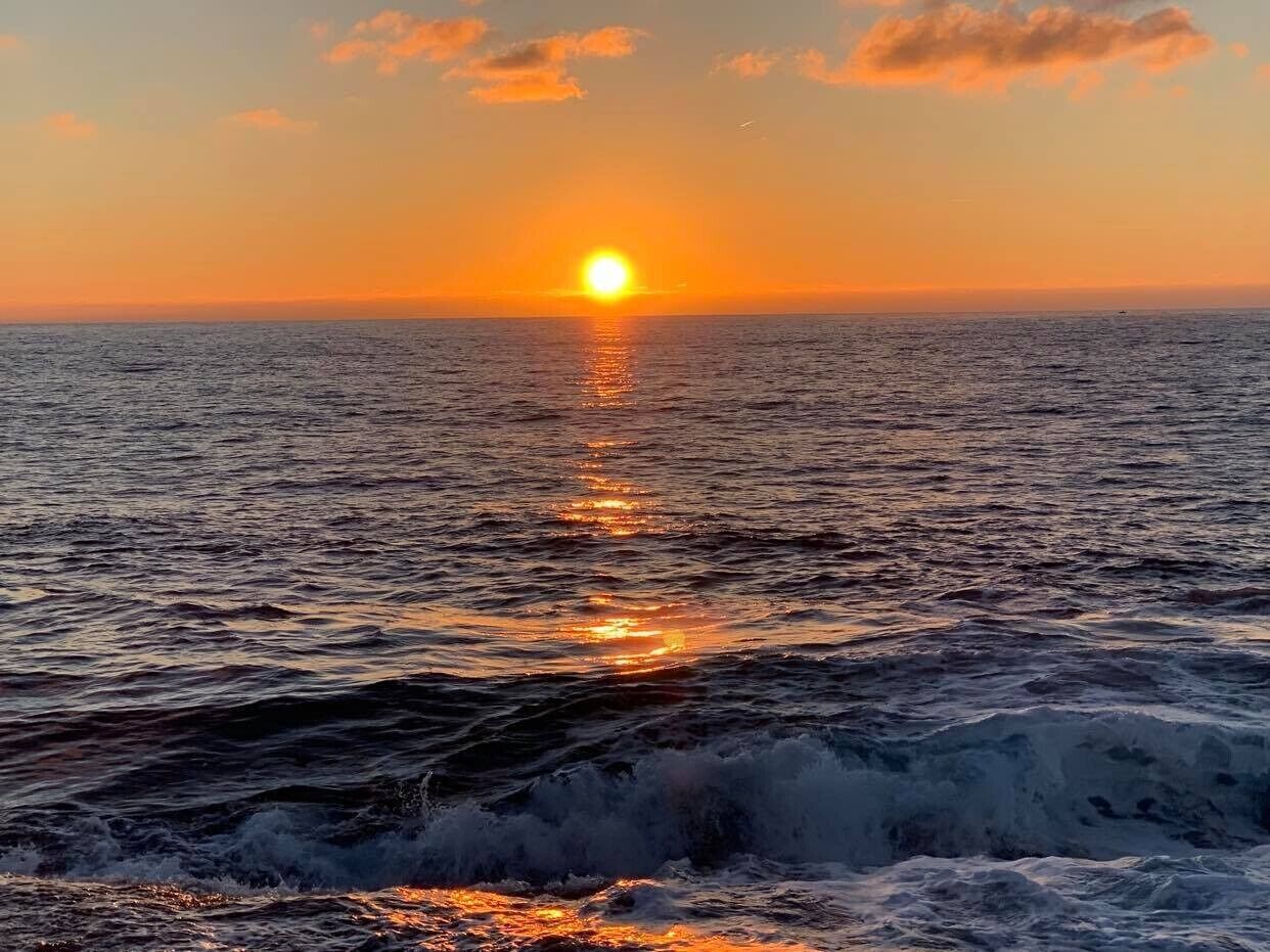 Un atardecer sobre el océano con olas.