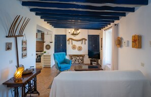 A bedroom with a bed, a blue armchair, a television, and a fireplace. - Holiday Home Casa Altavista with Pool, Wi-Fi, Air Conditioning, Terrace & Garden (Alora)