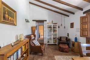 Un salon chaleureux avec une bibliothèque, un canapé en cuir marron, un meuble en bois et un coin repas.