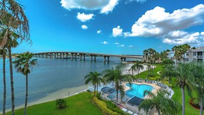 A pool area with a bridge in the background. - Bahia Vista 9-521 by Distinctive Beach Rentals (St. Petersburg)