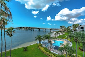 A pool area with a bridge in the background. - Bahia Vista 9-521 by Distinctive Beach Rentals (St. Petersburg)