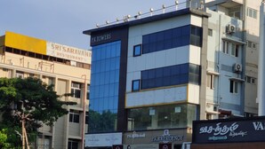 A multi-story building with signage for P.K. Towers, a restaurant, and a coffee shop. - P K Rresidency (Madurai)