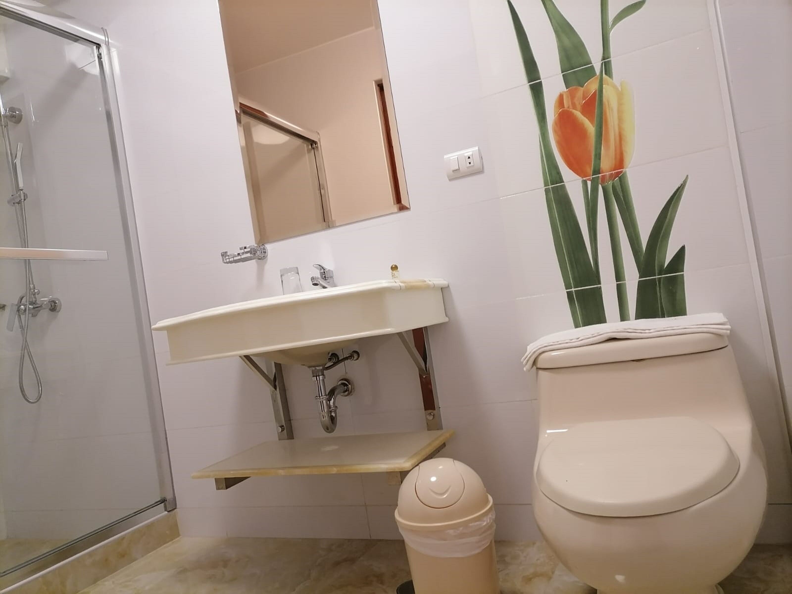 Un baño con ducha, lavamanos e inodoro.