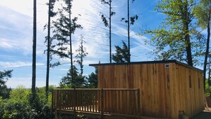 A wooden cabin with a deck, surrounded by trees and a clear sky. - Chalet Le Coquet, cozy n'est surrounded by greenery - Naturist area (Collonges-la-Rouge)