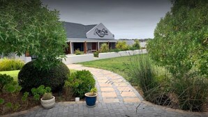 A house with a garden pathway leading to a covered porch. - Rox and Sea Country Lodge (Langebaan)