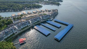 An aerial view of a waterfront hotel with multiple buildings, docked boats, and a marina.