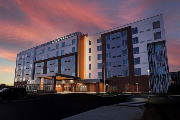 A Courtyard by Marriott hotel with a modern design, multiple floors, and a well-lit entrance. - Courtyard by Marriott Indianapolis Fishers (Fishers)