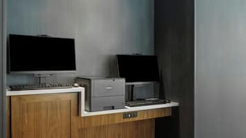 A modern office desk with two monitors, a keyboard, and a printer.