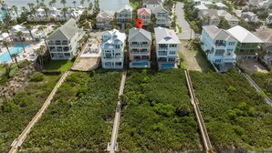 An aerial view of a coastal residential area with houses, a beach, and a lake. - Coastal Heaven by Distinctive Beach Rentals (Palm Coast)