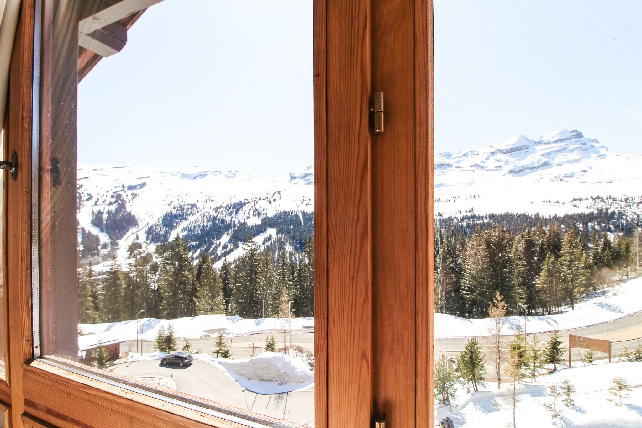 Ein Zimmer mit einem großen Fenster und Blick auf eine verschneite Berglandschaft.
