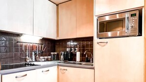 Eine moderne Küche mit Edelstahlgeräten, Holzschränken und einer gefliesten Rückwand.