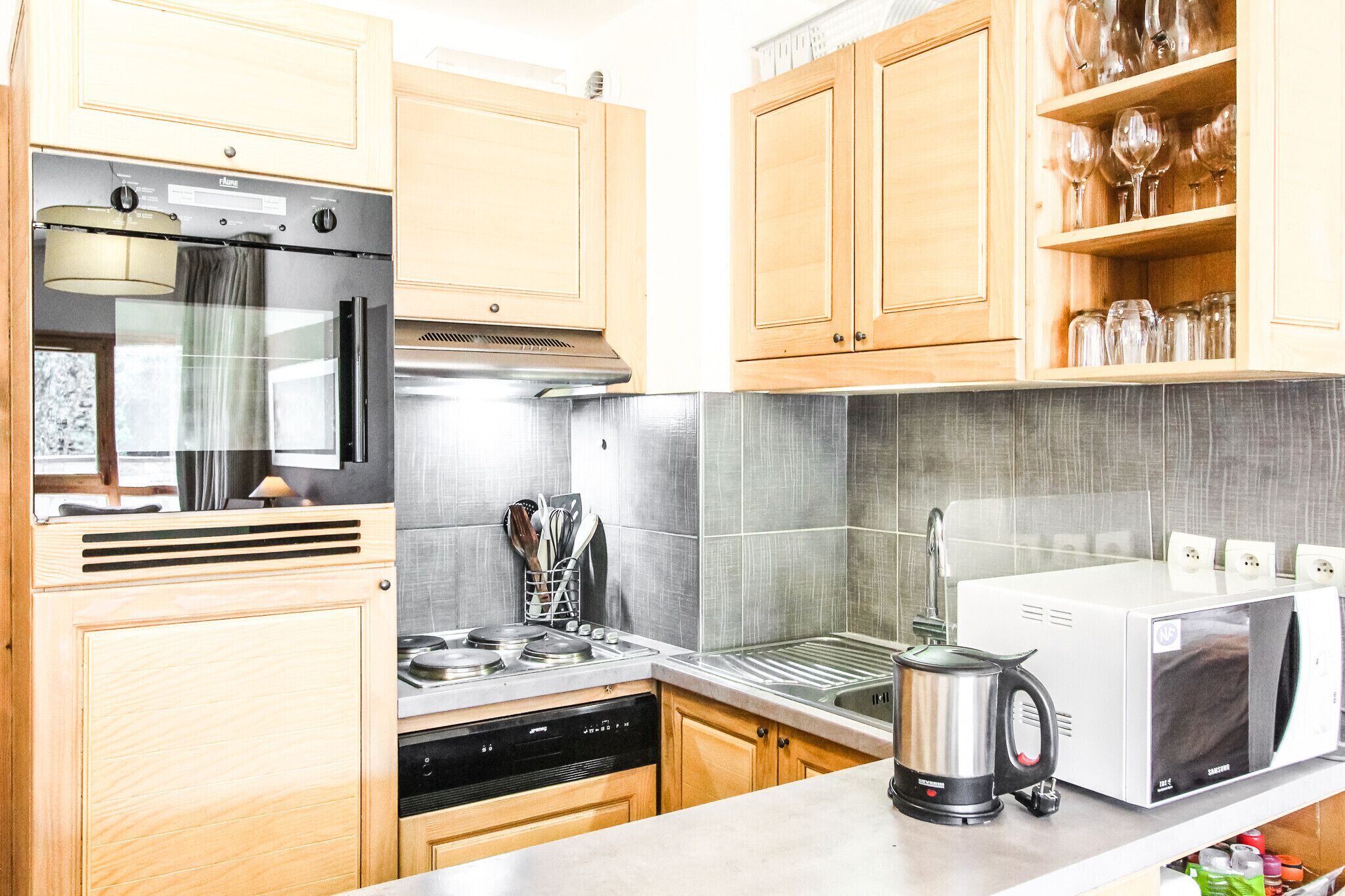 A kitchen with wooden cabinets, stainless steel appliances, and a microwave.