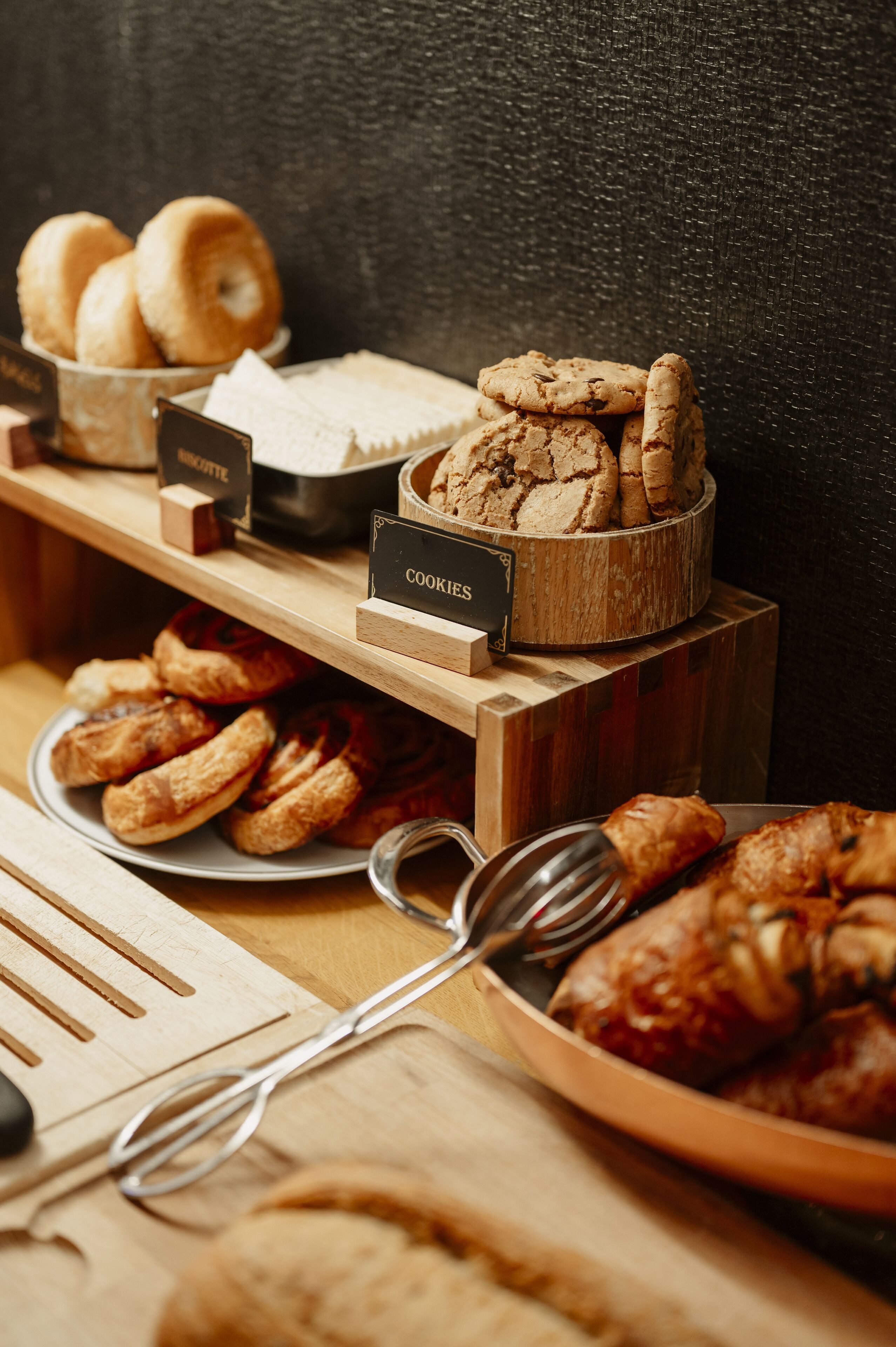 Een presentatie van verschillende gebakken producten, zoals koekjes, gebak en brood, op houten plankjes.