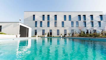 Una piscina al aire libre, camas de piscina gratis, sombrillas