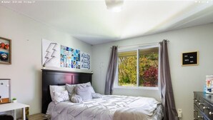 Ein Schlafzimmer mit einem Bett, einem Schreibtisch und einem Fenster.