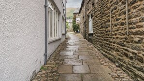 A narrow cobblestone alley flanked by buildings with stone and stucco exteriors. - 2 Kings Yard (Sedbergh)