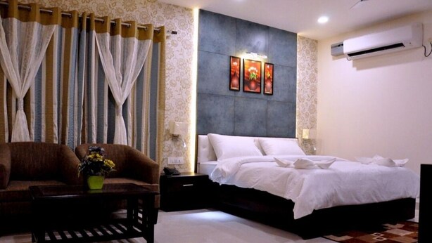 Un dormitorio con cama, sofá, mesita de noche y aire acondicionado de pared.