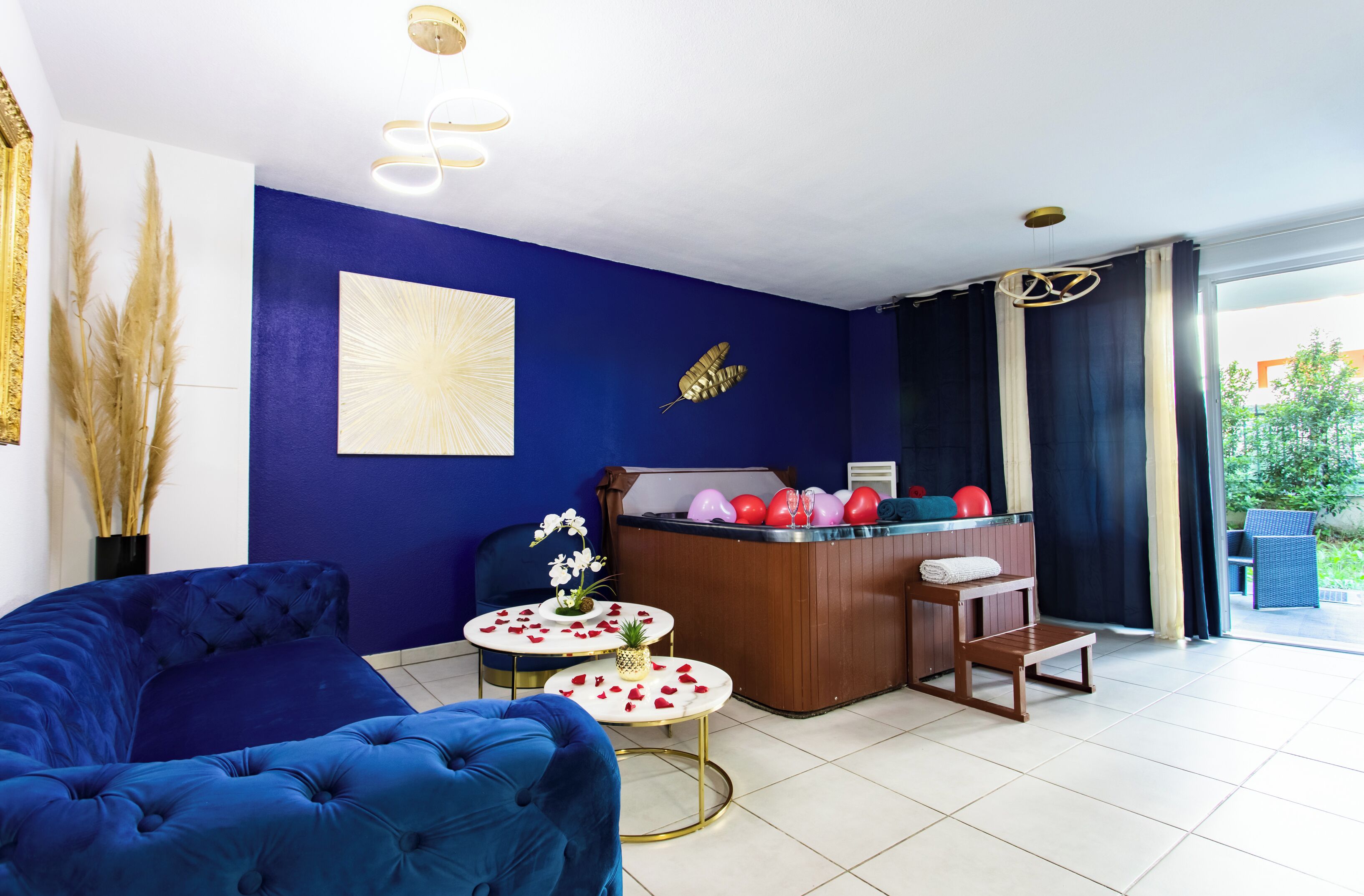 Een kamer met een blauwe bank, een houten receptiebalie en een kleine tafel met een ananas en bloemen.