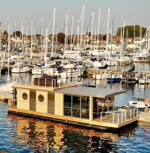 Ein Yachthafen mit mehreren dort angestuerten Booten, darunter ein Boot mit einer Kabine, und eine Anlegestelle, die ins Wasser ragt.
