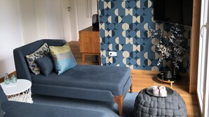 Un salon moderne comprenant un canapé, une table basse et une plante décorative.