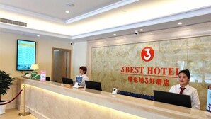 A hotel reception desk with a digital screen, a clock, and a sign indicating it's the 3BEST HOTEL. - Vienna 3 Best Hotel (Hangzhou)