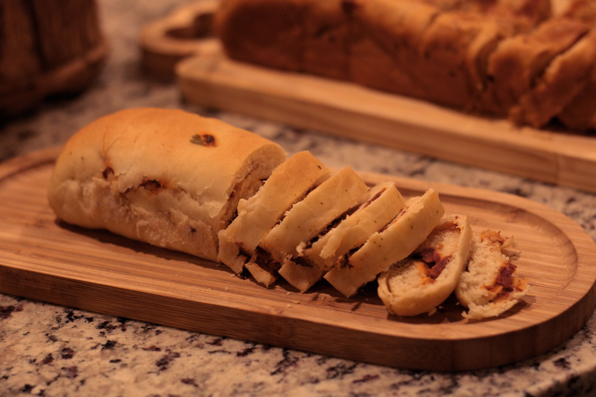 A loaf of bread sliced on a wooden cutting board.