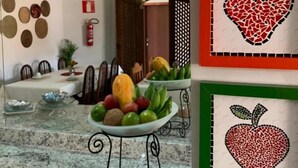 A dining area with a marble countertop, a fruit bowl, and a hanging light fixture. - Pousada Capim Limão (Diamantina)