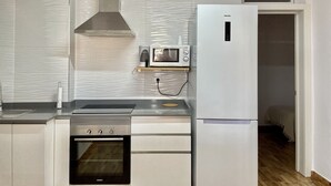 Uma cozinha moderna com forno embutido, micro-ondas e exaustor de aço inoxidável.