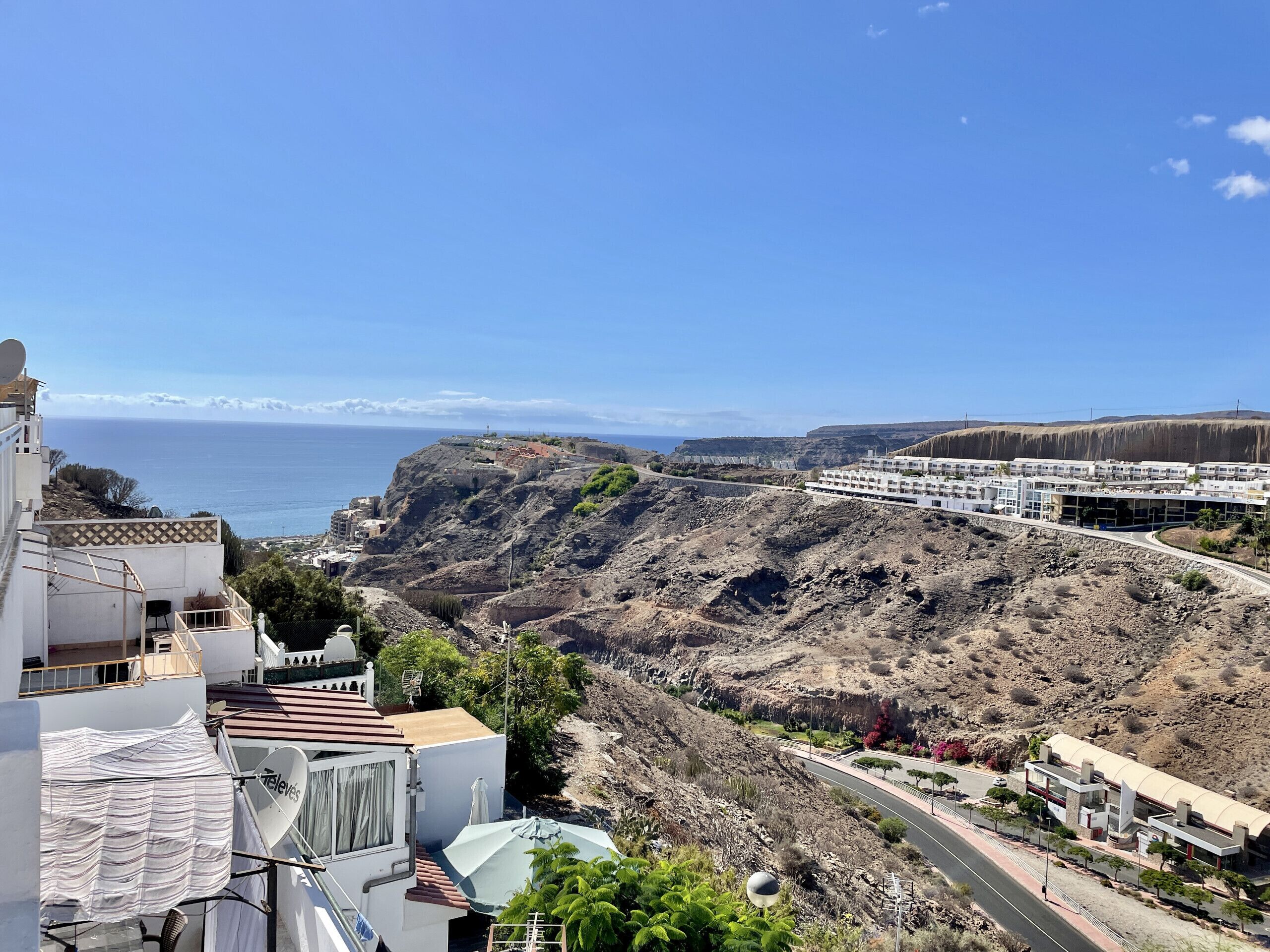 Un hotel costero con vistas al mar, un paisaje rocoso y un edificio moderno de techo curvo.