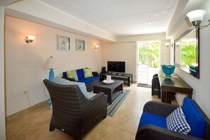 A living room with a sofa, a television, and a dining area with a table and chairs. - 3 min walk from the beach - Bella Figura (Apt 3) (Hastings)