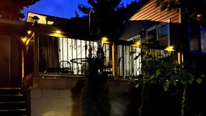 A modern house with a covered patio, a small garden, and a staircase leading to the entrance. - Waterfront cottage with great view  (parry sound)