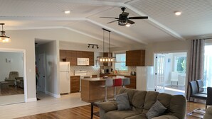 A spacious living area with a large sofa, a coffee table, and a kitchen in the background. - Waterfront cottage with great view  (parry sound)