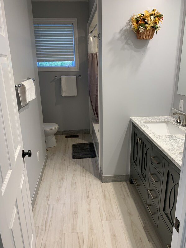 A bathroom with a toilet, a sink, a shower, and a window with blinds. - Waterfront cottage with great view (parry sound)