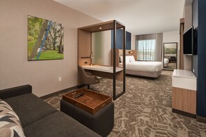 A hotel room with a large bed, a desk, a chair, a TV, and a painting on the wall. - SpringHill Suites by Marriott Winter Park (Winter Park)
