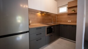 Uma cozinha moderna com forno embutido, pia e janela sobre a bancada.