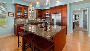 A modern kitchen with wooden cabinets, granite countertops, and stainless steel appliances.
