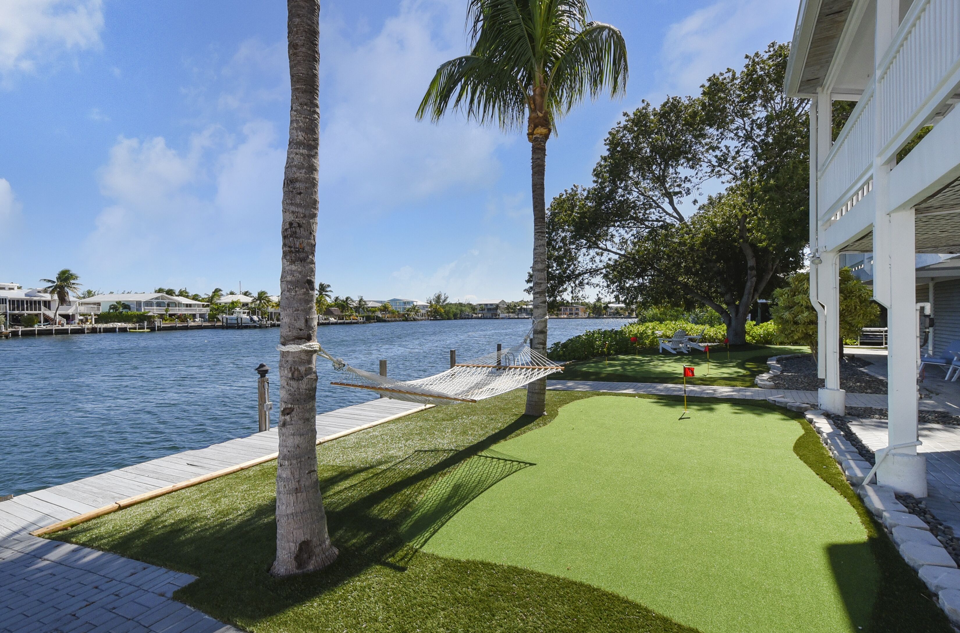 A waterfront property with a hammock, artificial turf, and a view of the water.