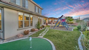 A modern house with a patio, a swing set, and a small putting green. - Zion Reunion Poolhouse, PRIVATE POOL, SLEEPS 24! (Washington)
