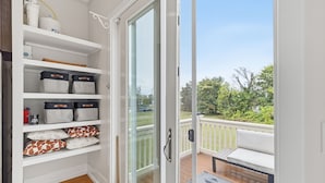 Ein Balkon mit einer weißen, gepolsterten Bank und einem gemusterten Teppich.