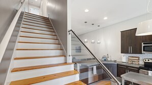 Eine moderne Küche mit einer Holztreppe und einem Glasgeländer.